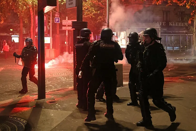 La police tente de disperser des supporters du PSG qui allument des feux d’artifice pour célébrer leur victoire à Paris, samedi 30 mai 2026.