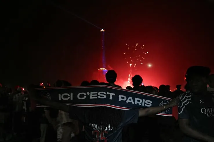 Supporters du PSG illuminant Paris après la victoire en Ligue des champions