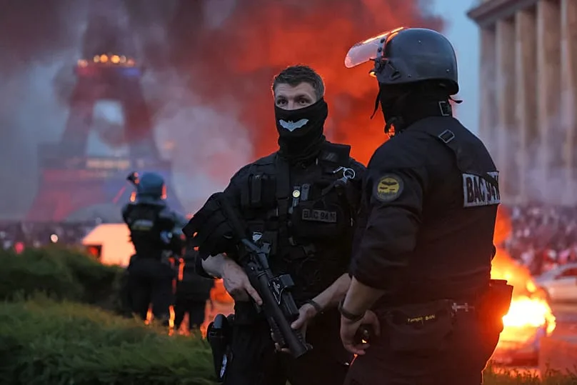 Une voiture brûle et des feux d’artifice éclatent tandis que la police surveille les supporters du PSG qui célèbrent à Paris, samedi 30 mai 2026.