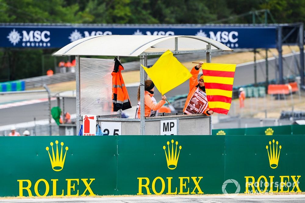 Marshals brandissant le drapeau jaune sur le circuit, image illustrant la proposition de sanction de Carlos Sainz