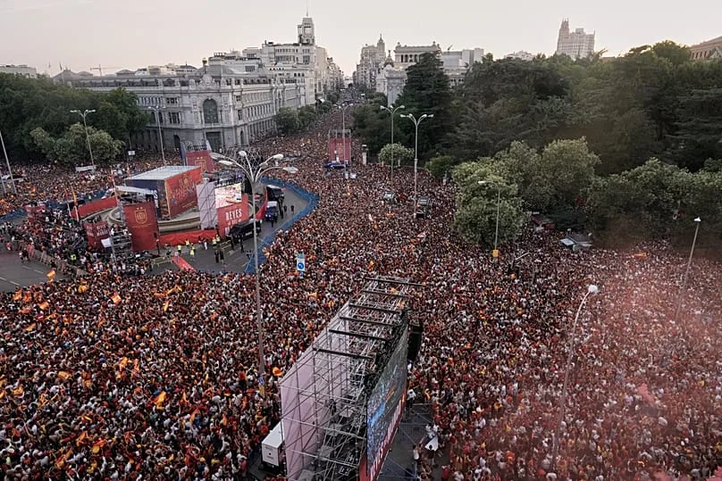 Supporters rassemblés sur la rue Princesa à Madrid, attendant l'arrivée du bus des champions du monde, 20 juillet 2026
