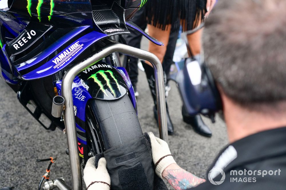 Techniciens vérifiant la pression d'un pneu pendant la course