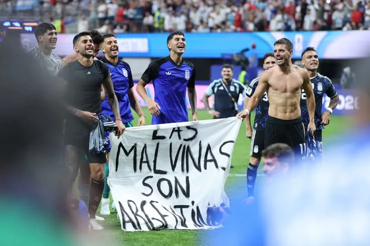 Célébration de la victoire de l'Argentine à Atlanta, joueurs brandissant la banderole des Malouines