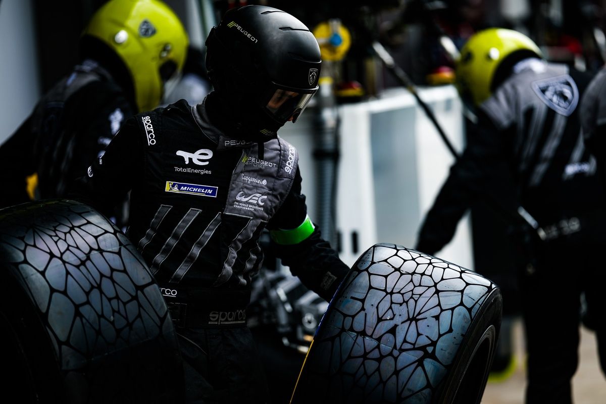 Mécaniciens Peugeot manipulant des pneus pluie lors du WEC