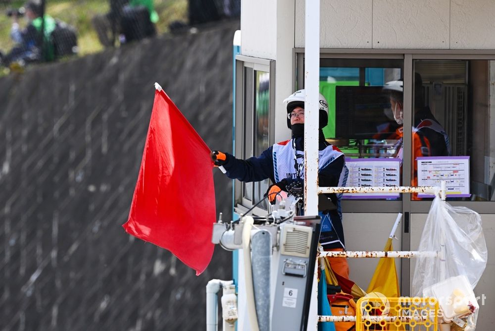 Un commissaire agite un drapeau rouge lors d’une interruption de course